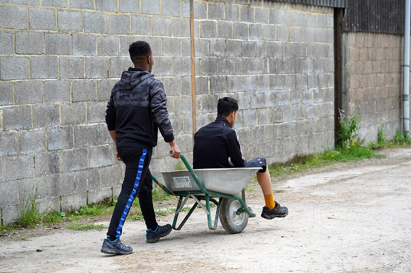 Picture of a young person being pushed along in a wheelbarrow © Big Leaf Foundation