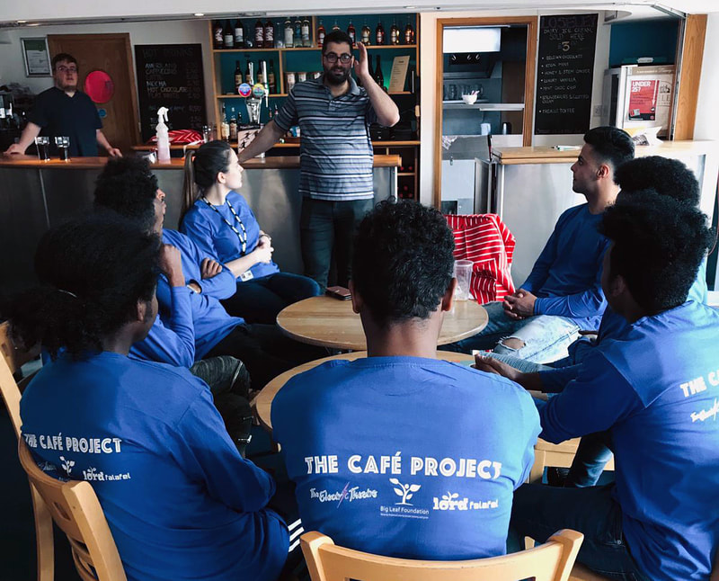 Picture of Muhammad talking to the group of young people The Cafe Project