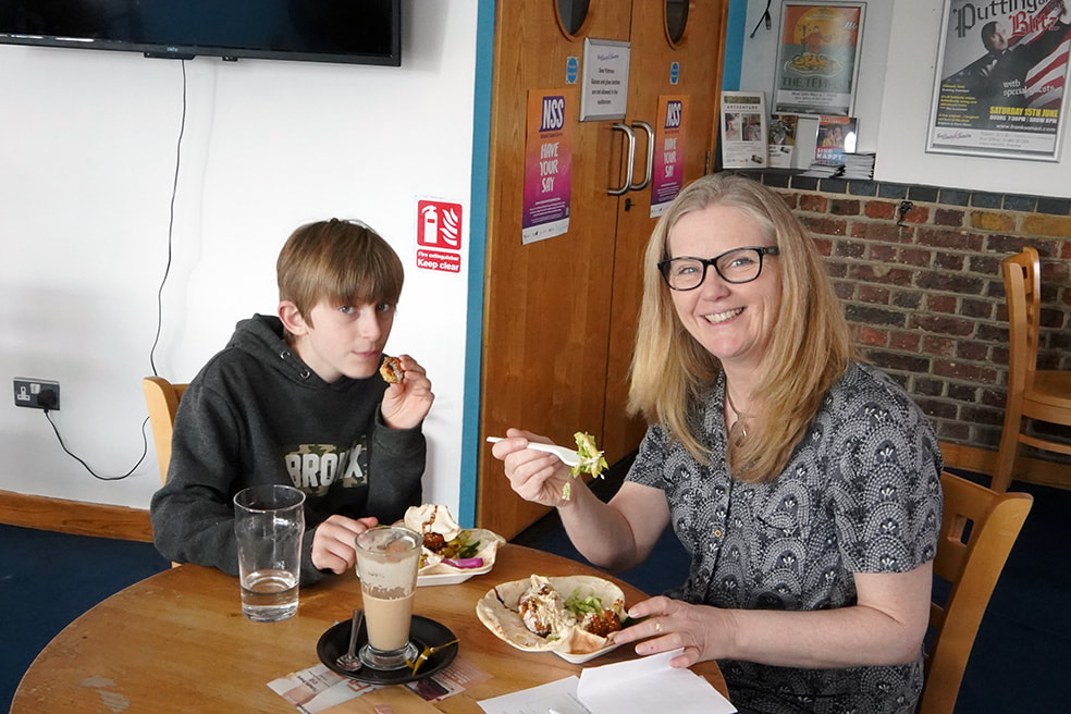 Picture of two happy customers eating falafel at The Cafe Project
