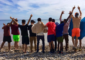 Picture of young people standing on a beach arms raised in celebration © Vicki Felgate