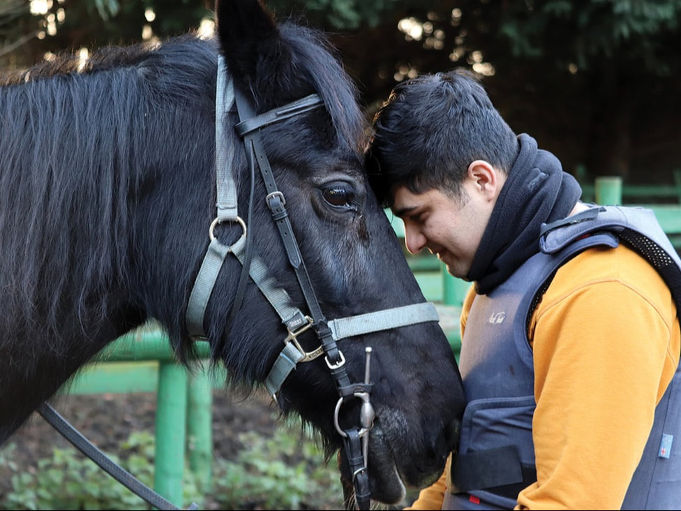 An image of a young person hugging a horse