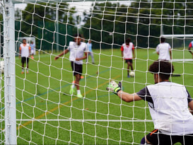 Image of young people outdoors scoring a goal