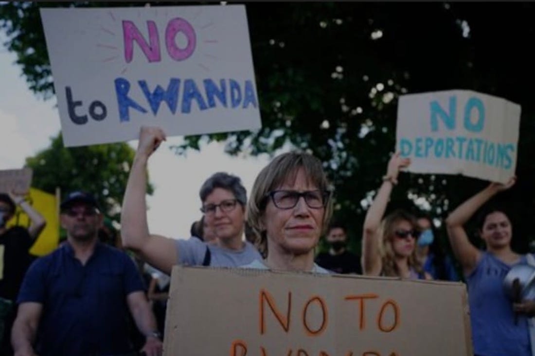 Image of people holding 'No to Rwanda' signs