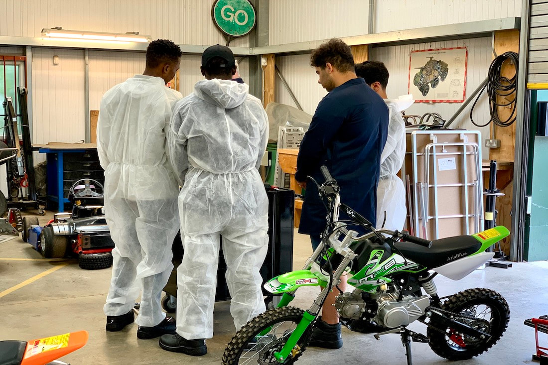 An image of three young people in a mechanics workshop © Big Leaf Foundation